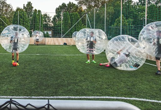 A group playing bubble football on the outdoor pitch